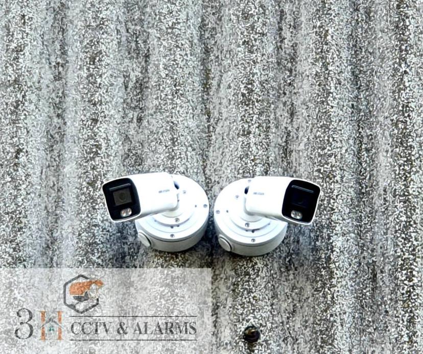 Two Hikvision bullet cameras mounted on commercial unit